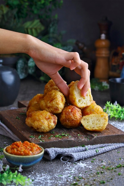 Photo une main saisissant un morceau de fromage d'un pain