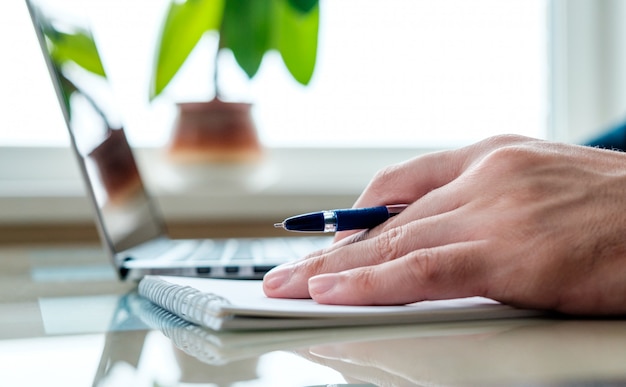 La main avec un stylo au bureau