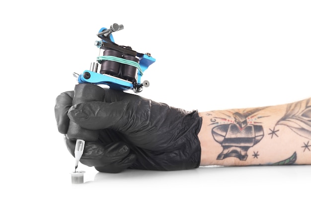 Main de tatoueur dans un gant noir avec machine à tatouer isolée, gros plan