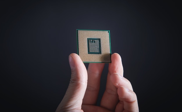 Main de technicien tenant le processeur cpu du pc.