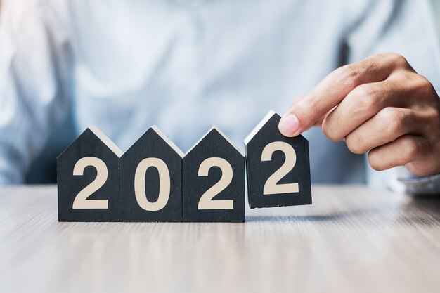 main tenant 2022 bonne année avec modèle de maison