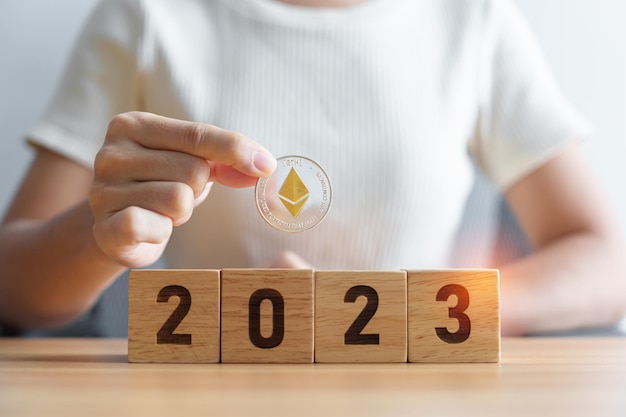 Main tenant de l'argent Ethereum ou ETH cryptocurrency sur 2023 blocs de l'année Crypto trading est la blockchain de l'argent numérique et les concepts du Nouvel An