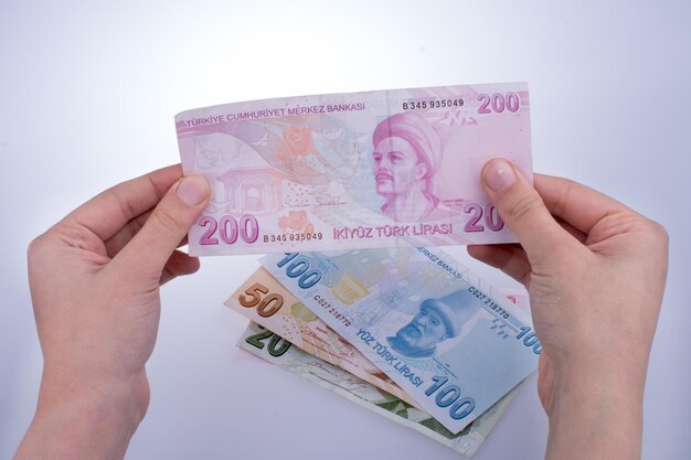 Main tenant le billet de banque de Turksh Lira dans la main