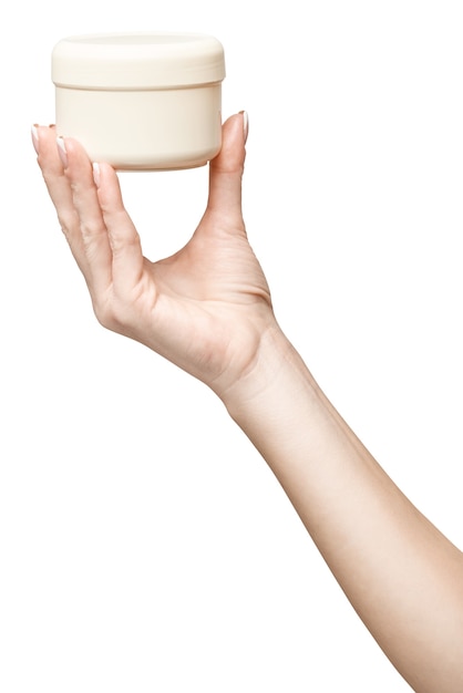 main tenant une boîte en plastique de crème isolé