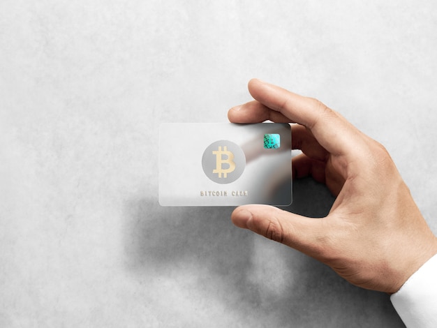 Main tenant la carte bitcoin avec logo or en relief