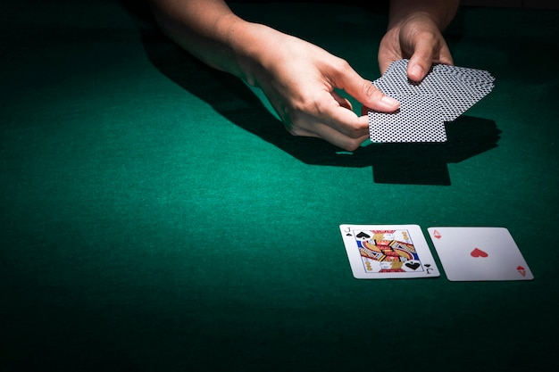 Photo main tenant des cartes de poker sur la table de casino
