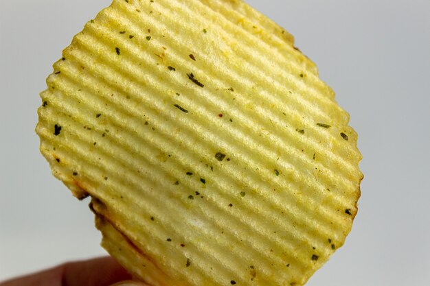 Main tenant des chips isolés sur blanc.