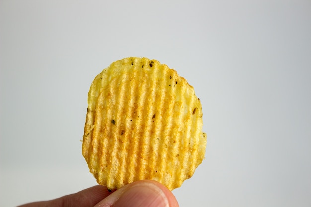 Main tenant des chips isolés sur blanc.