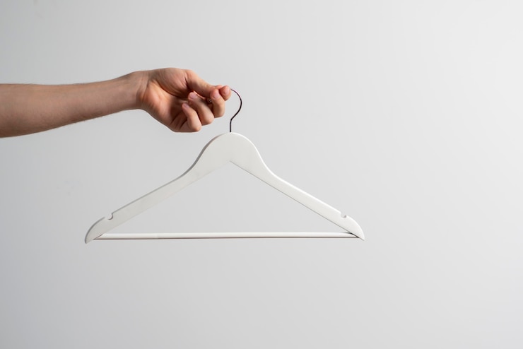 Photo une main tenant un cintre en tissu vide