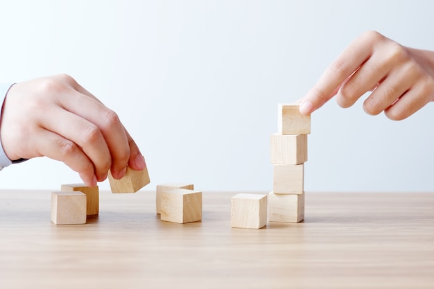 Main tenant des cubes en bois blancs