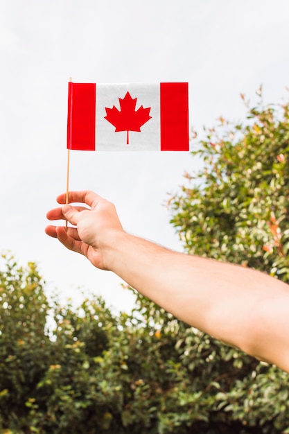 Photo main tenant le drapeau canadien à l'extérieur