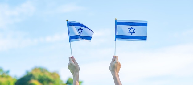 Main tenant le drapeau d'Israël sur fond de nature Israël fête de l'indépendance et concepts de célébration heureuse