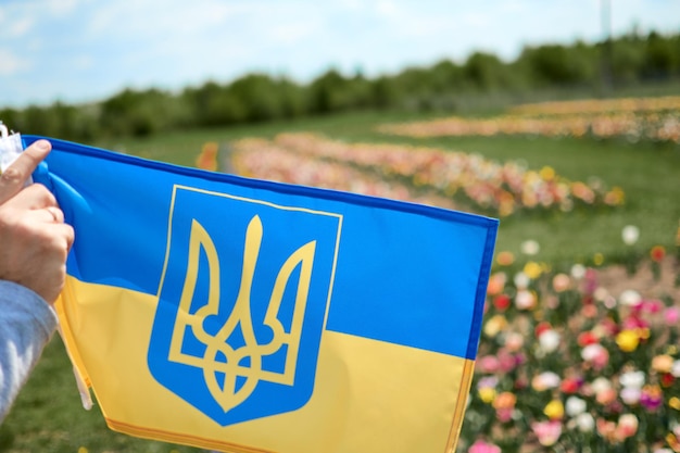 Main tenant le drapeau ukrainien sur fond jaune bleu Guerre de la Russie contre l'Ukraine