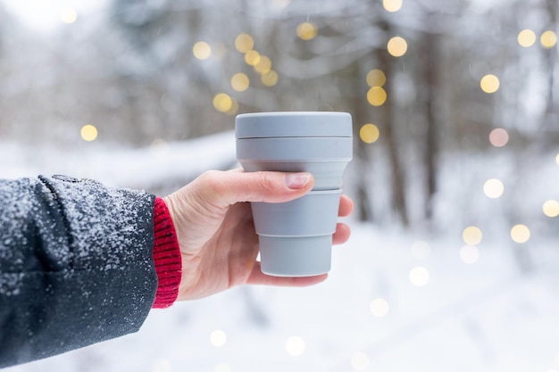 Main tenant à emporter une tasse de café en silicone écologique à emporter une tasse de thé pendant les vacances d'hiver vacances de Noël