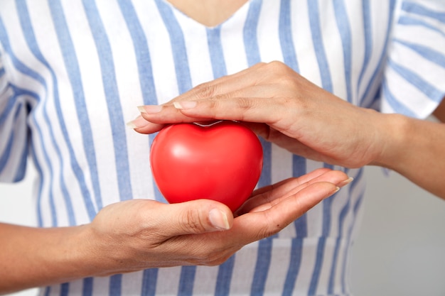 Main tenant en forme de coeur rouge