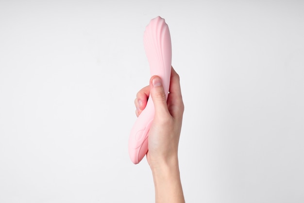 Main tenant un jouet sexuel pour les femmes sur blanc.