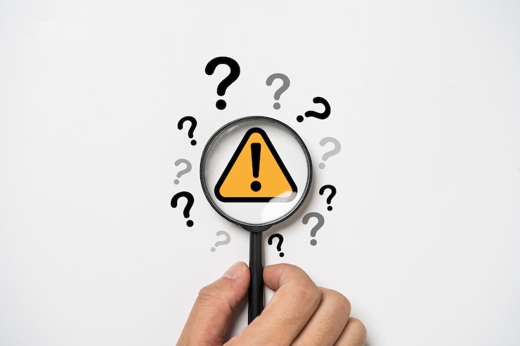 Photo main tenant une loupe avec un panneau d'avertissement de mise en garde triangle jaune et un point d'interrogation pour l'erreur de notification et le concept de maintenance