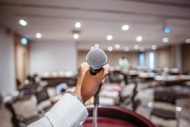 Main tenant le microphone dans la salle de conférence