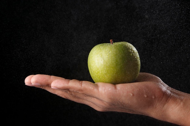 main tenant une pomme verte