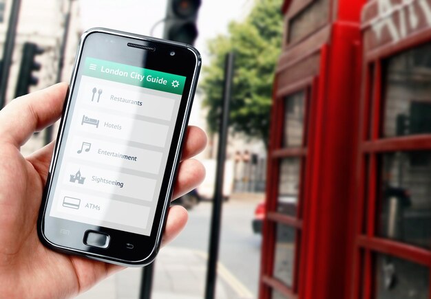 Main tenant un smartphone avec un guide de la ville de Londres