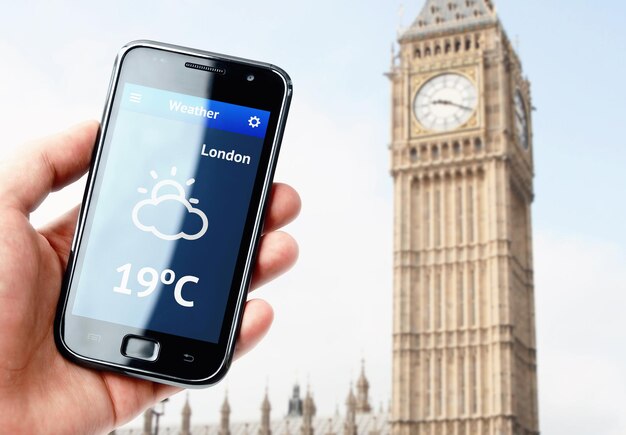 Main tenant un smartphone avec la météo à Londres