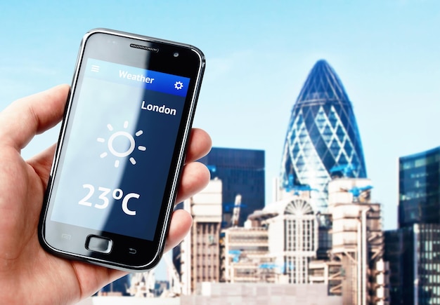 Main tenant un smartphone avec la météo à Londres