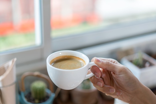 Main tenant une tasse de café chaud