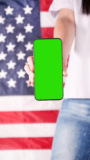 Main tenant un téléphone portable avec écran vert Drapeau des États-Unis d'Amérique sur fond Téléphone maquette