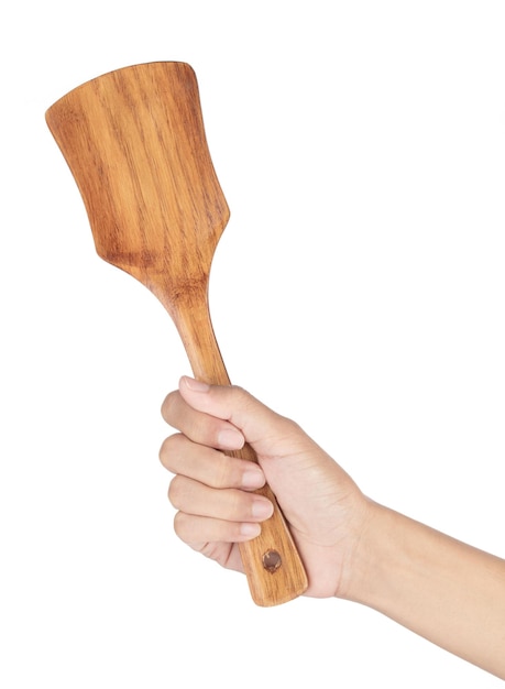 Main tenant le tourneur de spatule en bois isolé sur fond blanc.
