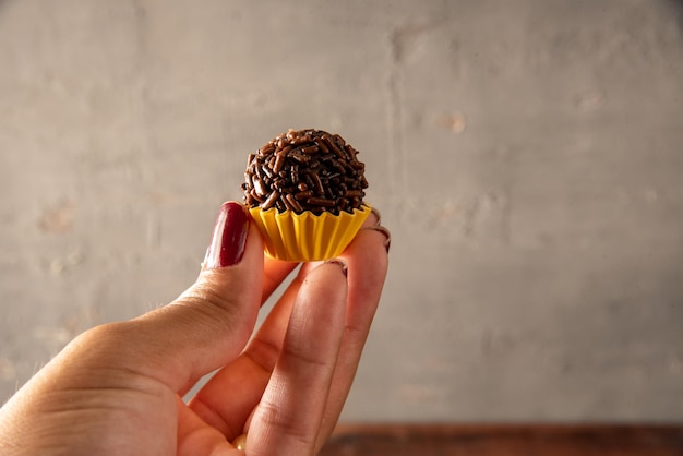 Une main tenant une truffe au chocolat avec le haut vers le bas