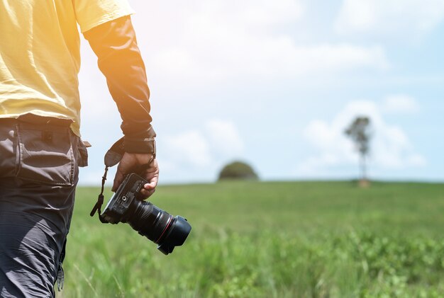 Main tenir la caméra avec vue sur la nature