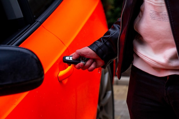 Main tenir la clé de la voiture ouvrant la porte de la voiture