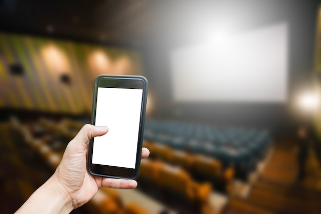 Main tenir sur mobile avec fond de cinéma