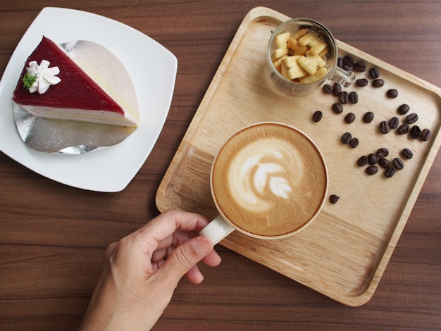 main tenir tasse café avec gâteau