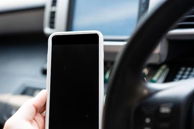 Main tenir un téléphone portable vierge dans la voiture pour la technologie