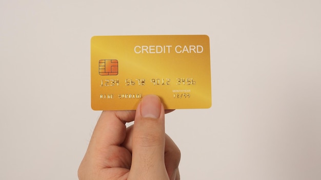 La main tient une carte de crédit en or isolée sur fond blancx9