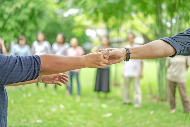 La main tient ensemble dans la communauté dans le jardin / parc.