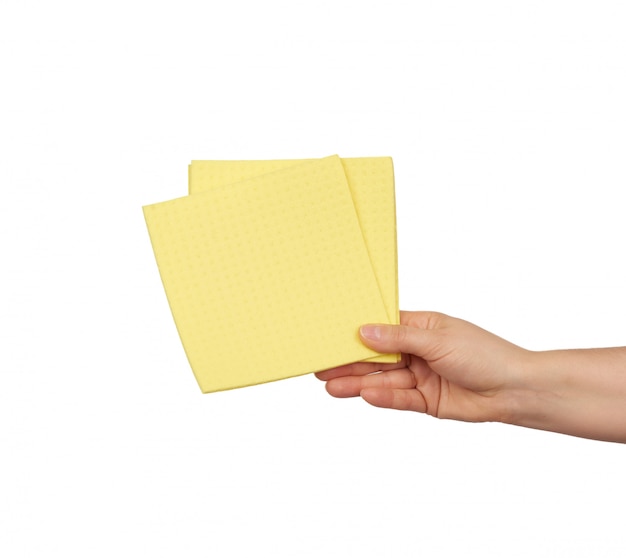 Main tient une éponge de chiffon jaune pour le nettoyage