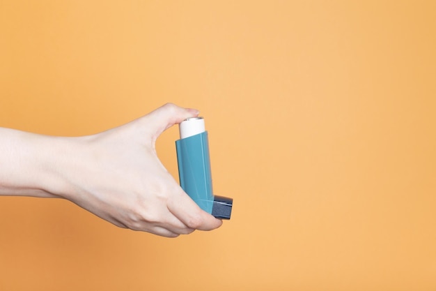 La main tient l'inhalateur pour traiter l'asthme Journée mondiale de l'asthme Concept de soins contre les allergies Copier l'espace