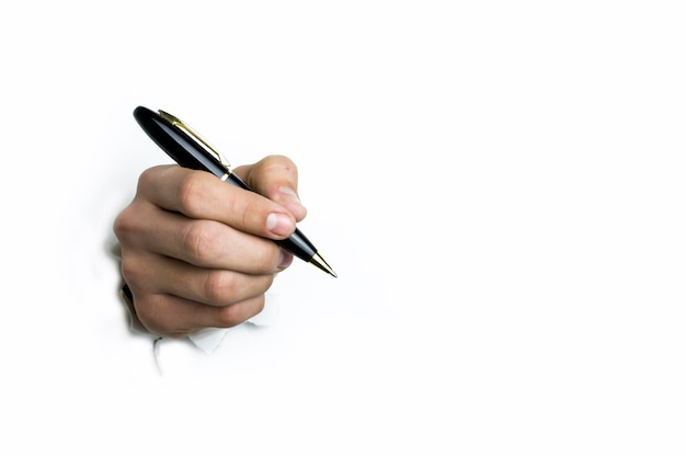 La main tient un stylo à bille noir sur fond blanc