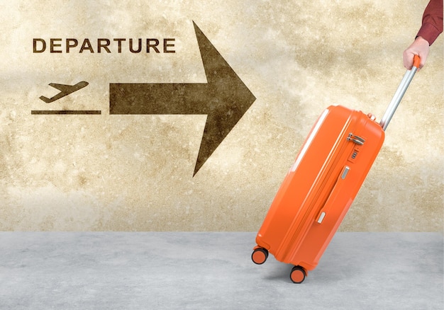 Main tient une valise orange sur fond blanc Bagages à roulettes passager Valise de voyage en plastique orange avec poignée à glissière et serrure vue latérale rapprochée