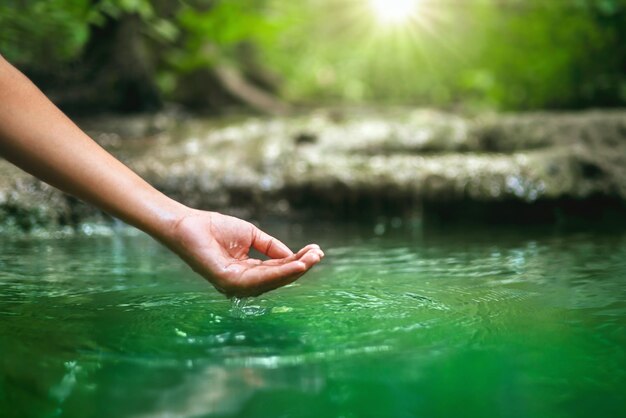 La main touche l'eau dans l'étangxA