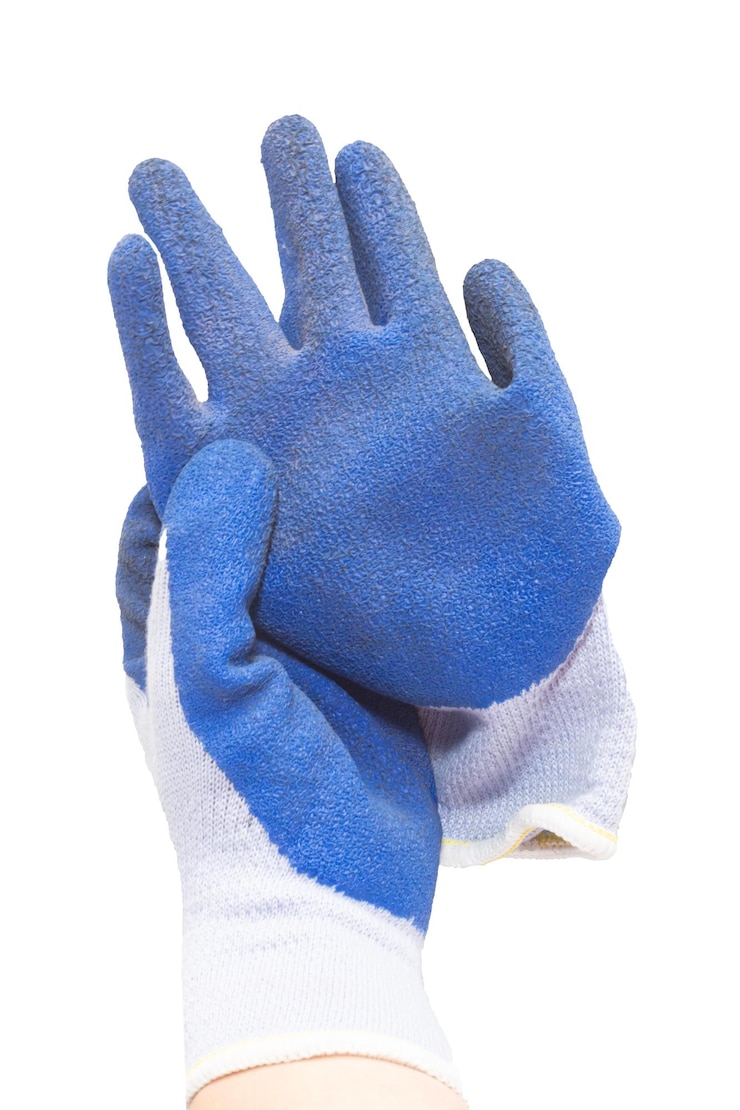 Photo la main de travail portant un gant de travail bleu tient l'autre gant de la paire sur un fond blanc