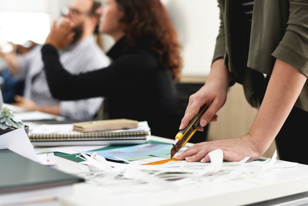 Main utilisant du papier de coupe au bureau