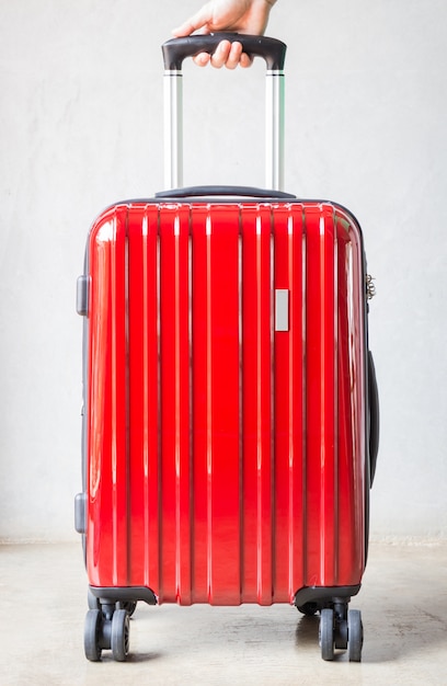 Main sur la valise rouge