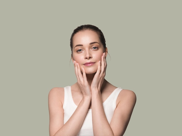 Main De Visage De Femme En Bonne Santé De Belle Peau Touchant Le Fond De Couleur De Peau Fraîche Propre Et Saine. Vert