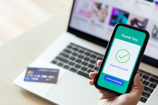 mains à l'aide d'un smartphone pour le paiement en ligne