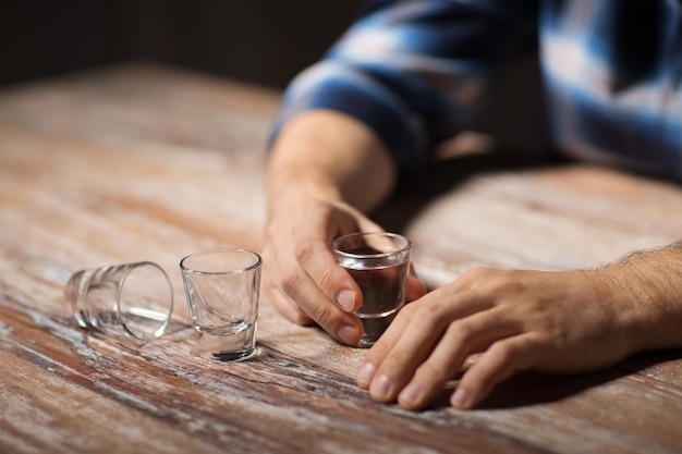 Photo mains d'alcooliques buvant des coups de vodka la nuit