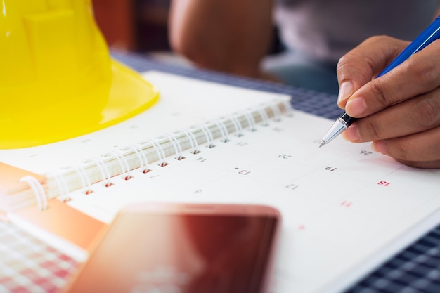 Photo les mains de l'architecte planifient et gèrent le travail sur le concept de planification du calendrier