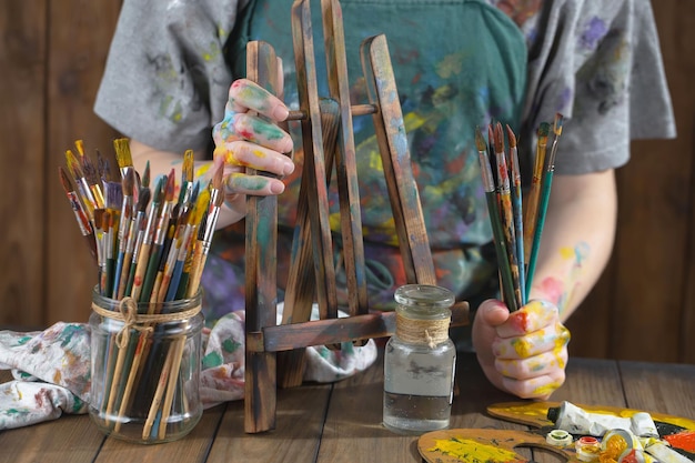 Mains d'artiste féminine avec des pinceaux